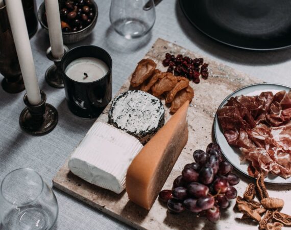 A picture of different foods such as cheeses and meats