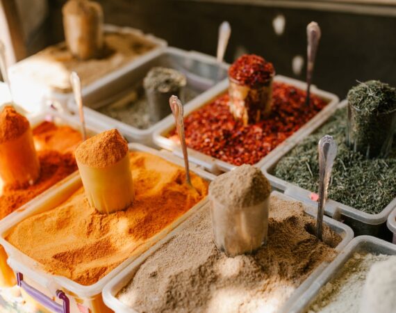 A picture of different colored spices and flours in containers.